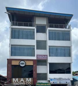 un edificio blanco alto con un cartel delante en Hotel Landmark, en Port Blair