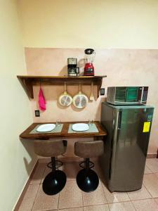 a small kitchen with a table and a refrigerator at Departamento Fila in Puerto Escondido +3 photos