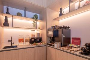 a kitchen with a counter with food and a refrigerator at Jill Hotel Brussels Centre Midi in Brussels