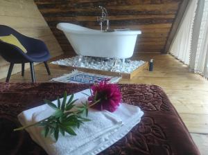 a bath tub sitting in a room with a table at Noapte de Poveste in Piatra Fantanele