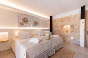 a white bedroom with a large bed with white pillows at Vila Nova Suites & SPA in Capdepera +58 photos