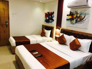 a hotel room with two beds in a room at Grandeur By Avion Palace Near T2 International Airport in Mumbai +14 photos