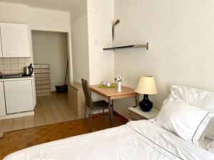 a bedroom with a bed and a table and a kitchen at 300m from the train station in Lausanne