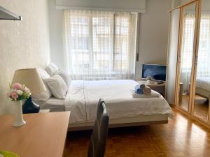 a bedroom with a bed and a couch and a television at 300m from the train station in Lausanne