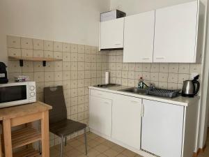 a kitchen with white cabinets and a sink and a microwave at 300m from the train station in Lausanne