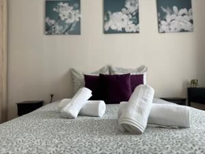 a bed with two rolled towels on top of it at Lumineux & cosy proche Paris & La Défense, commerces & transports, PARKING in Suresnes