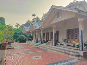 a house with a brick walkway in front of it at Jacob's Homestay in Wayanad
