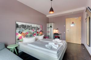 a bedroom with a white bed and white walls at MEININGER Hotel Berlin Alexanderplatz in Berlin