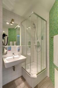 a bathroom with a shower, sink, and toilet at MEININGER Hotel Berlin Alexanderplatz in Berlin