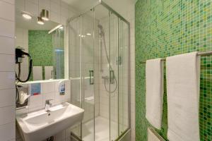 Un baño con ducha de cristal y lavabo. en MEININGER Hotel Berlin Alexanderplatz, en Berlín 28 fotos más