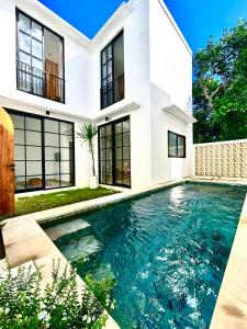 a swimming pool in front of a house at Bukawa Residences Balangan in Jimbaran