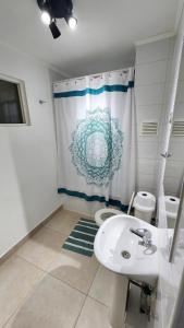a bathroom with a sink and a toilet and a shower curtain at Comfortable y central depto 2D 2B with parking in Los Ángeles