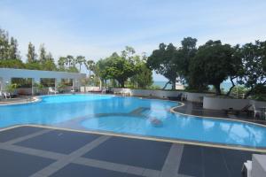 a large swimming pool with a person in the water at Jomtien Plaza Suite Apartments in Jomtien Beach