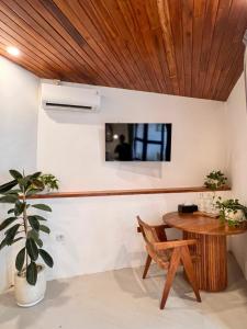 Habitación con techo de madera y mesa de madera. en Chic 1BR in Bingin 3 Mins to Top Cafes & Beach, en Uluwatu