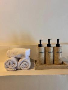 Un grupo de tres toallas en un estante en un baño. en Chic 1BR in Bingin 3 Mins to Top Cafes & Beach, en Uluwatu
