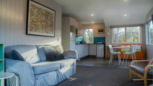a living room with a couch and a kitchen at Arrowtown Gold - Elevated Two Bedroom Apartment in Arrowtown