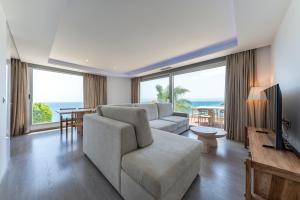 a living room with a couch and a tv and some windows at Montiboli Apartments by Buccara in Villajoyosa