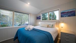 a bedroom with a bed with two towels on it at Arrowtown Gold - Elevated Two Bedroom Apartment in Arrowtown