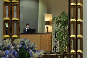 a woman sitting at a podium in a room with a laptop at Antoinette Hotel Wimbledon in London