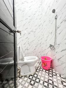 a bathroom with a toilet and a pink bucket at Grand Kalasan Homestay Jogja in Tanjungtirto +39 photos