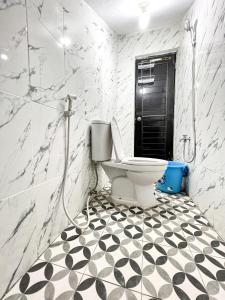 a bathroom with a toilet and a black door at Grand Kalasan Homestay Jogja in Tanjungtirto