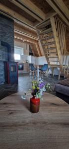 a vase with flowers in a room with stairs at D&N place - forest house Zabljak in Žabljak