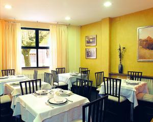 a restaurant with white tables and chairs and a window at Hotel Casa El Rapido in Felechosa