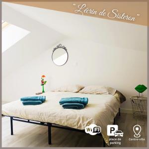 a bedroom with a bed with blue pillows on it at L'écrin de Sisteron - lac, centre-ville et parking in Sisteron