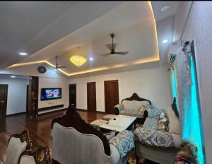 sala de estar con sofás, mesa y TV en Shree Krishna Dham 3BHK Villa with Private Pool and Lush Garden in Noida sector 135, en Noida
