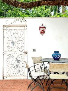 a patio with a table and chairs and a gate at Casa Monetti By CapriRooms in Capri