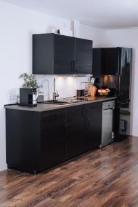 a kitchen with black cabinets and a black counter top at Brīvdienu māja Sniegi in Madona +34 photos