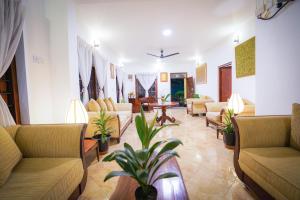 a waiting room with couches and tables and plants at Weligama Bungalow in Weligama