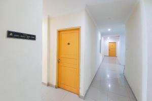 a hallway with a yellow door in a building at RedDoorz Hotel Baaraka near Living World in Pekanbaru