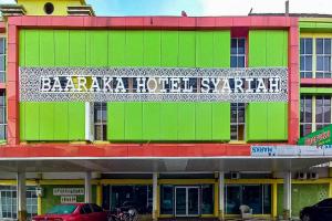 a building with a sign on the side of it at RedDoorz Hotel Baaraka near Living World in Pekanbaru