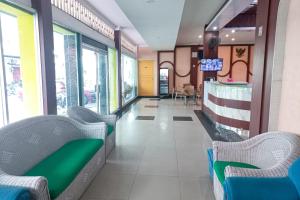 a waiting area of a hospital with chairs and tables at RedDoorz Hotel Baaraka near Living World in Pekanbaru +34 photos