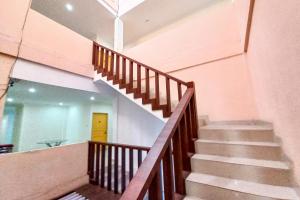a wooden staircase in a building with a mirror at RedDoorz Hotel Baaraka near Living World in Pekanbaru