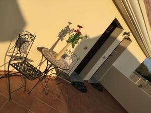 a table topped with chairs and a vase filled with flowers at Residence Olbia in Olbia