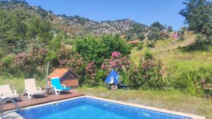une piscine avec des chaises et une maison dans l'établissement Togo iztuzu Stonehouse-2, à Gökbel 9 autres photos