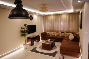 a living room with a couch and a tv at Luxury 1BR Near the Airport in Cairo