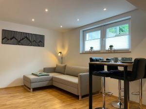a living room with a couch and a table at 1,5-Zimmer, Top ausgestattet, 4 Pers, Souterrain, Self Check-in, Parkplatz, Netflix & Amazon Prime in Flintsbach