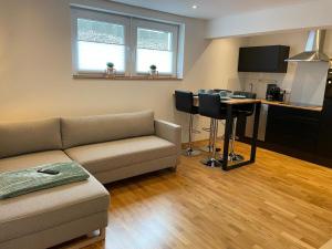 ein Wohnzimmer mit Sofa und Tisch in der Unterkunft 1,5-Zimmer, Top ausgestattet, 4 Pers, Souterrain, Self Check-in, Parkplatz, Netflix & Amazon Prime in Flintsbach + 21 Fotos
