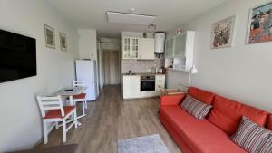 un salon avec un canapé rouge et une cuisine dans l'établissement Summer, à Palanga