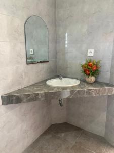 een badkamer met een wastafel en een spiegel bij Sanur Base Apartment in Denpasar +9 foto's