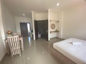een slaapkamer met een bed, twee stoelen en een tafel bij Sanur Base Apartment in Denpasar