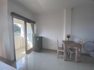 een eetkamer met een tafel en stoelen en een raam bij Sanur Base Apartment in Denpasar