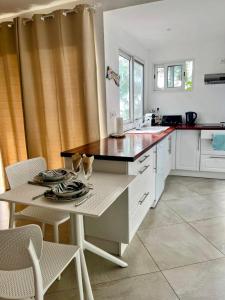 eine Küche mit Tisch und Arbeitsplatte in der Unterkunft Suite by Chalet de Tahiti in Punaauia