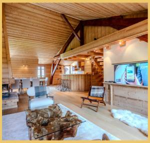 圣热尔韦莱班Appartement La Comtesse I Centre de Saint-Gervais的宽敞的客厅，配有木质天花板和平板电视