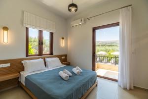 a bedroom with a bed with two towels on it at Villa Aetheria by PosarelliVillas in Plátanos +48 photos