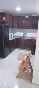 a wooden table in a kitchen with a black refrigerator at Boustan 5em N9 in Nador