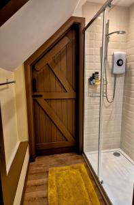 a bathroom with a shower and a sliding barn door at The Studio, Apedroc in Forest Row +65 photos